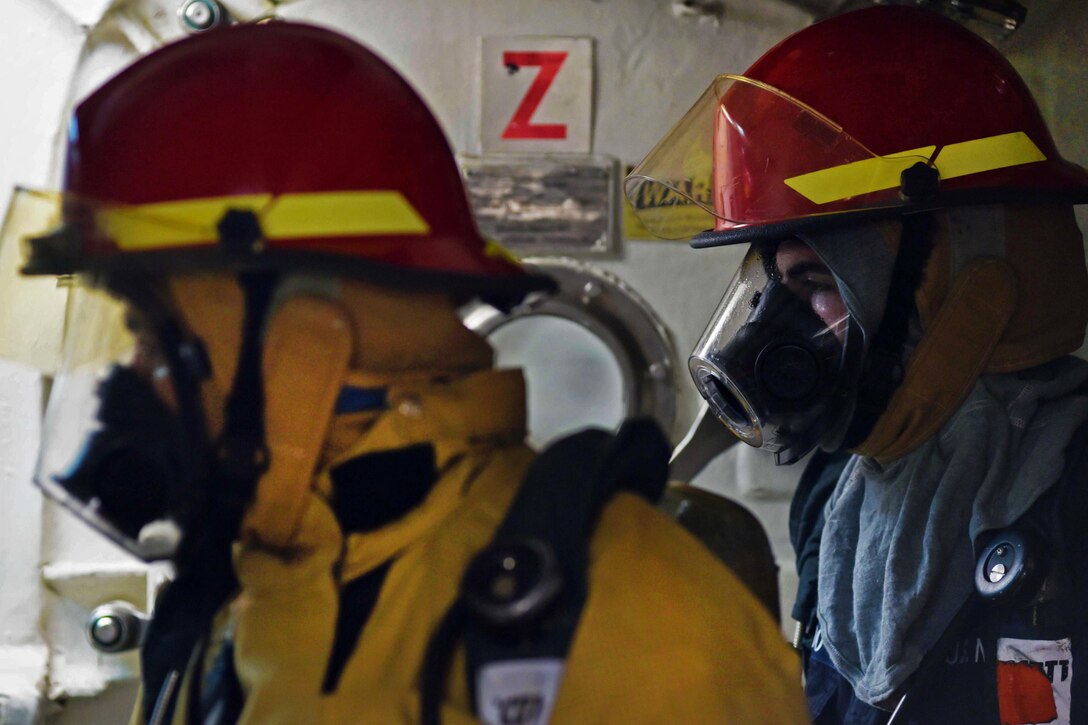 Navy Petty Officer 2nd Class Rafael Orellana, left, and Navy Petty Officer 3rd Class John Azevedo prepare to enter a main engineering area during a fire drill aboard the USS Ross in the Mediterranean Sea, Feb. 19, 2016. Orellana is a logistics specialist, and Azevado is a gas turbine systems technician electrical. Navy photo by Petty Officer 2nd Class Justin Stumberg