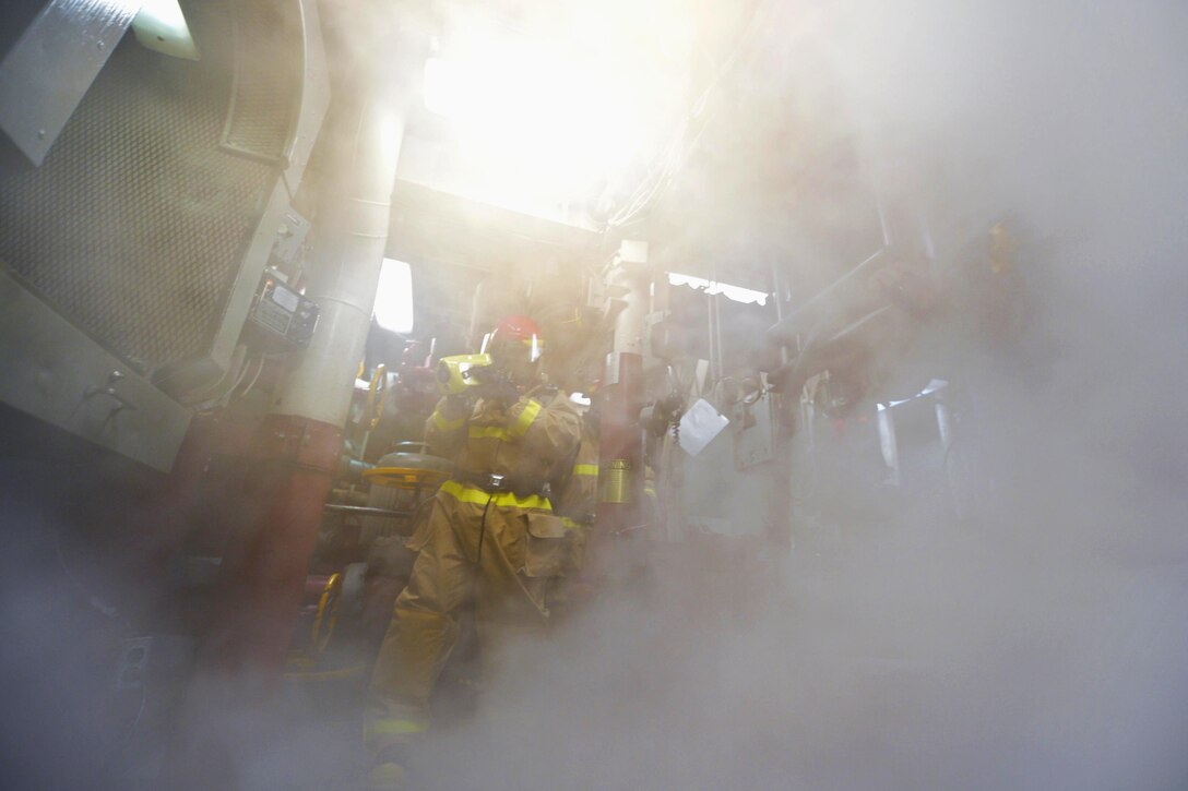 Navy Petty Officer 2nd Class Rafael Orellana, foreground, uses a firefighting thermal imager as he enters a smoked-filled area during a fire drill aboard the USS Ross in the Mediterranean Sea, Feb. 19, 2016. Orellana is a logistics specialist. Navy photo by Petty Officer 2nd Class Justin Stumberg