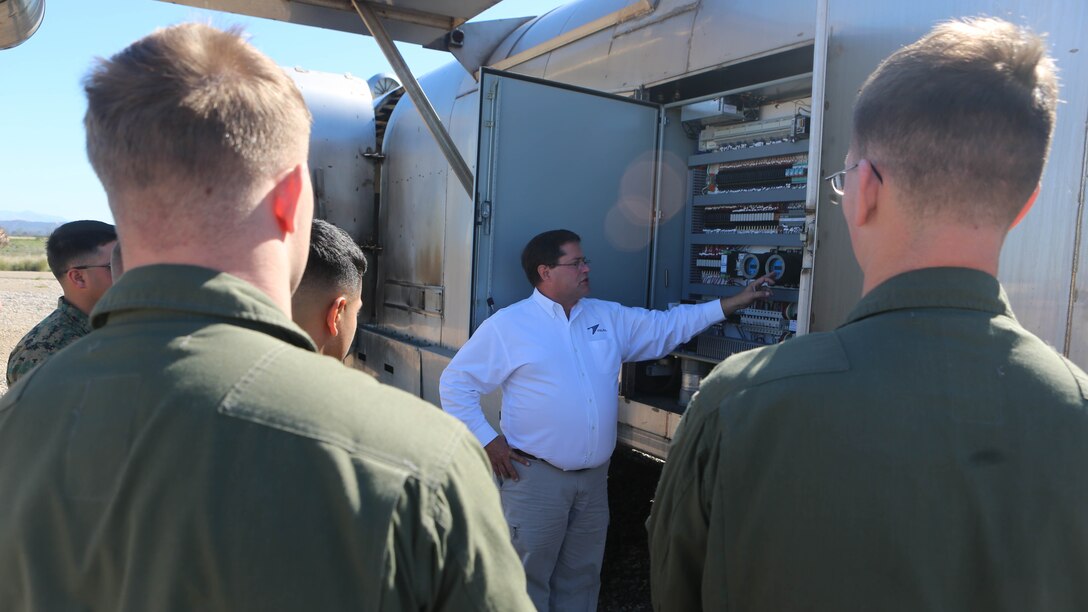 Greg Hudson, Mobile Aircraft Fire Training Device program manager and an Orlando, Florida, native, talks to the Marines about the functions of the Mobile Aircraft Fire Training Device aboard Marine Corps Air Station Miramar, California, Feb. 22. The MAFTD is a computer-operated device and the different functions are controlled via a panel. The MAFTD is used by Aircraft Rescue and Firefighting Marines to conduct live-fire training. 