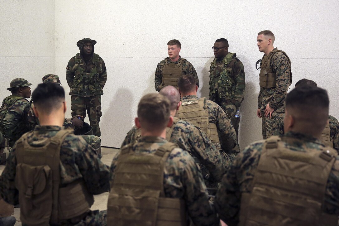 Marines with Combat Logistics Battalion 2 from a Theater Security Cooperation team give a weapons handling class to role players acting as a partner African military force at the Infantry Immersion Trainer on Camp Lejeune, N.C., Feb. 23, 2016. Marines with the battalion practiced the type of training they would provide in preparation for Special Purpose Marine Air-Ground Task Force-Crisis Response-Africa. (U.S. Marine Corps photo taken by Cpl. Alexander Mitchell/released)
