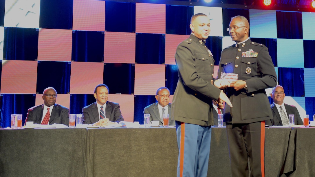 Lt. Col. David Everly, junior military assistant to the Secretary of Defense, is presented an award at the Black Engineer of the Year 11th Annual Stars and Stripes Dinner Feb. 19, 2016 at the Philadelphia Marriott Downtown Grand Ballroom in Philadelphia by Lt. Gen. Ronald Bailey, the Deputy Commandant Plans, Polices and Operations at Headquarters Marine Corps. “If you’re looking for excellence in military hands-on experience, look no further than Lt. Col. Dave Everly,” said Bailey. “Lt. Col. Everly epitomizes our values of courage, honor and commitment as a role model and a mentor.”  