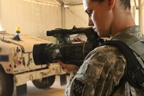 Sgt. Jessica Forester, a videographer in the Orlando, Fla., based 204th Public Affairs Detachment, records Army Reserve mechanics working on Humvees from a field exercise Feb. 18 at Fort Polk, La. Forester and fellow public affairs videographers and print journalists were tested on their abilities during Exercise News Day, the new culminating event for Army Reserve public affairs. (U.S. Army photo by Sgt. Brandon Hubbard, 204th Public Affairs Detachment/Released)