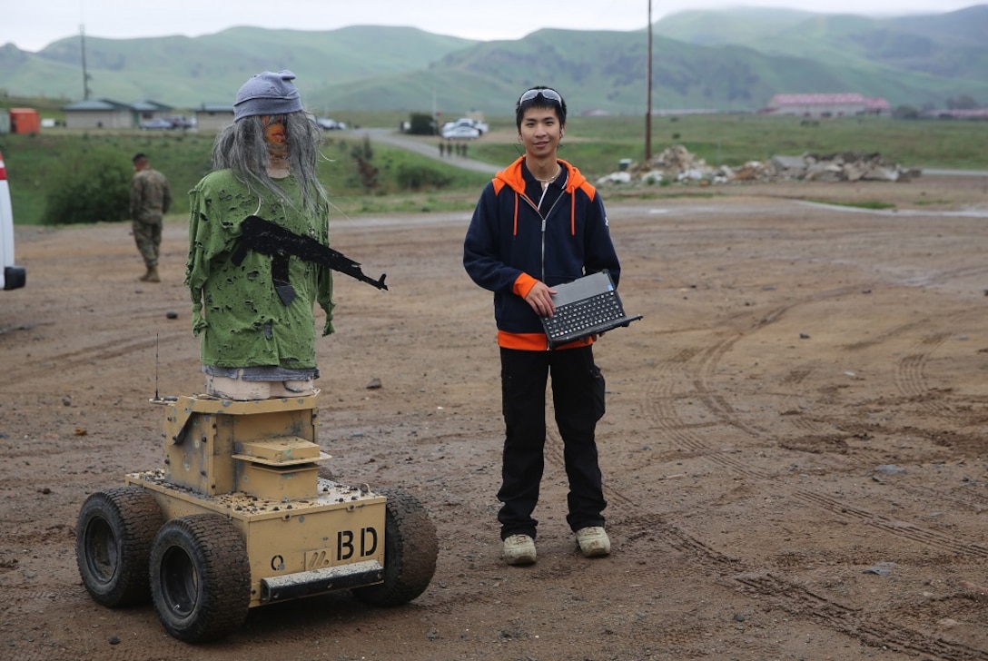 Nathan Fung poses with an Autonomous Robotic Human Type Target Feb. 18, at Camp Pendleton. Marines from Division Schools 1st Marine Division tested the targets to see if they could use them to evolve their training by creating more realistic, less predictable scenarios. Fung, a robotics engineer for Marathon Targets, is a native of Sydney, Australia. (U.S. Marine Corps Photo by Cpl. John Baker)