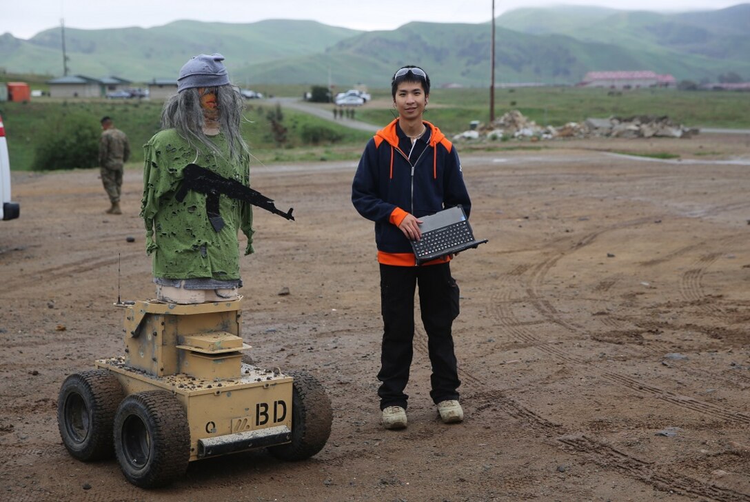 Nathan Fung poses with an Autonomous Robotic Human Type Target Feb. 18, at Camp Pendleton. Marines from Division Schools 1st Marine Division tested the targets to see if they could use them to evolve their training by creating more realistic, less predictable scenarios. Fung, a robotics engineer for Marathon Targets, is a native of Sydney, Australia. (U.S. Marine Corps Photo by Cpl. John Baker)