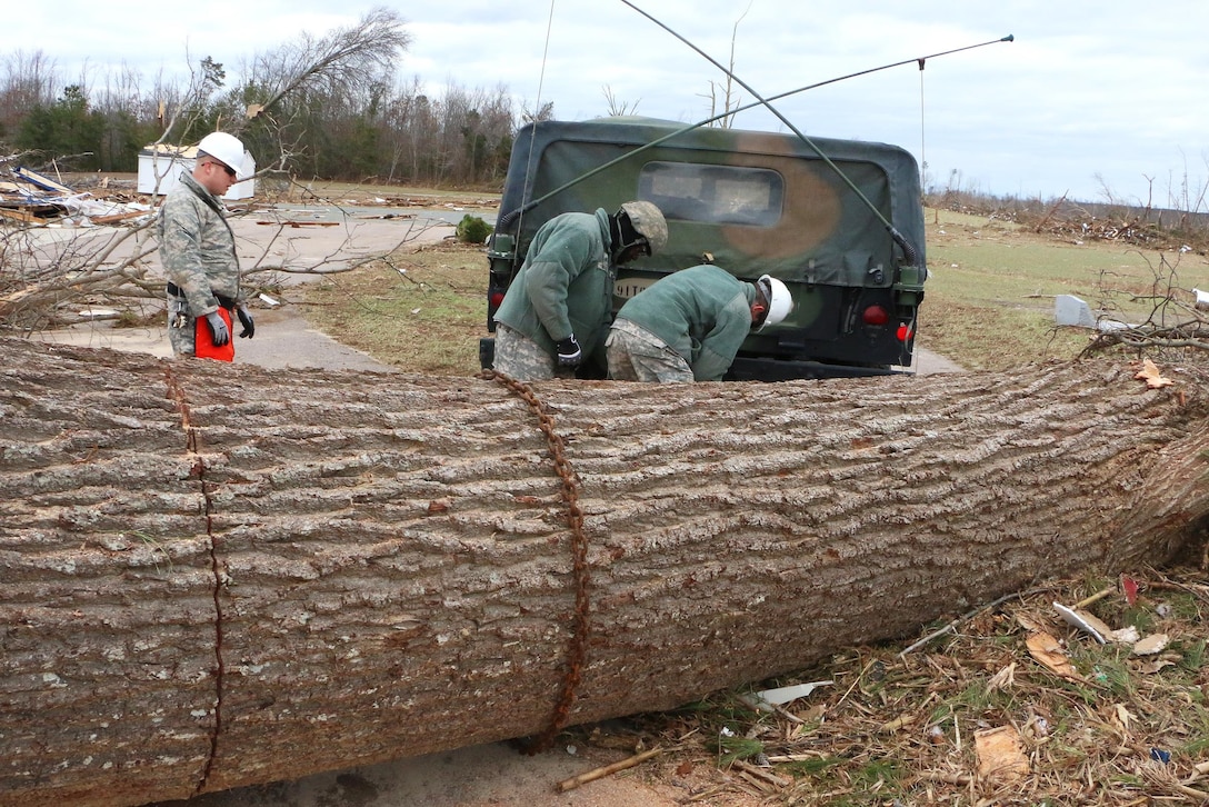 Soldiers wrap a chain around a large log and then hook it to a Humvee to open a blocked road in Essex County, Va., Feb. 25, 2016. Virginia National Guard photo by Alfred Puryear