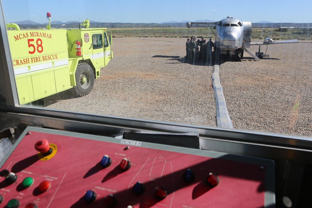 Aircraft Rescue and Firefighting Marines gather around the Mobile Aircraft Fire Training Device as Greg Hudson, MAFTD program manager and an Orlando, Fla., native, talks about the different functions of the device aboard Marine Corps Air Station Miramar, Calif., Feb. 24. The MAFTD is used by ARFF to conduct live-fire training. (U.S. Marine Corps photo by Lance Cpl. Harley Robinson/Released)