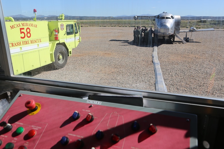 Aircraft Rescue and Firefighting Marines gather around the Mobile Aircraft Fire Training Device as Greg Hudson, MAFTD program manager and an Orlando, Fla., native, talks about the different functions of the device aboard Marine Corps Air Station Miramar, Calif., Feb. 24. The MAFTD is used by ARFF to conduct live-fire training. (U.S. Marine Corps photo by Lance Cpl. Harley Robinson/Released)