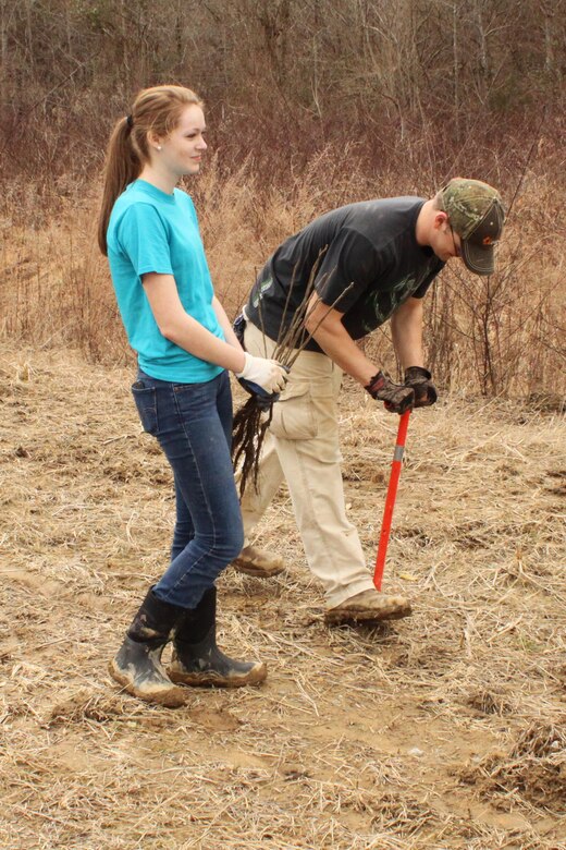 Junior ROTC Capt. Jonathan Keith and Cpl. Morgan Belcher plant seedlings during a project to restore the environment at a disposal area near Wolf Creek Dam in Jamestown, Ky.