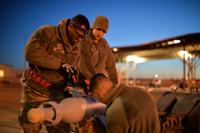 Airman Juan Rivas, Senior Airman Darion White and Staff Sgt. Jeffrey Kalsbeek, 34th Aircraft Maintenance Squadron load crew members, prepare to equip an F-35A with a GBU-12 laser-guided bomb at Hill Air Force Base, Utah, Feb. 23, 2016. (U.S. Air Force photo by R. Nial Bradshaw) 