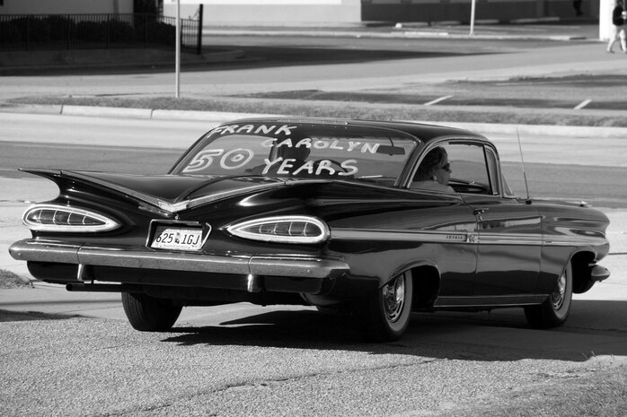 Frank Metzger, a 437th Airlift Wing program analyst, drives away in a 1959 Chevrolet Impala with his wife, Carolyn, after renewing their wedding vows for their 50th anniversary, Oct. 5, 2013. Carolyn surprised Metzger with the car upon leaving the ceremony; it was the same year and model as the one he drove when they were dating. (Courtesy Photo) 