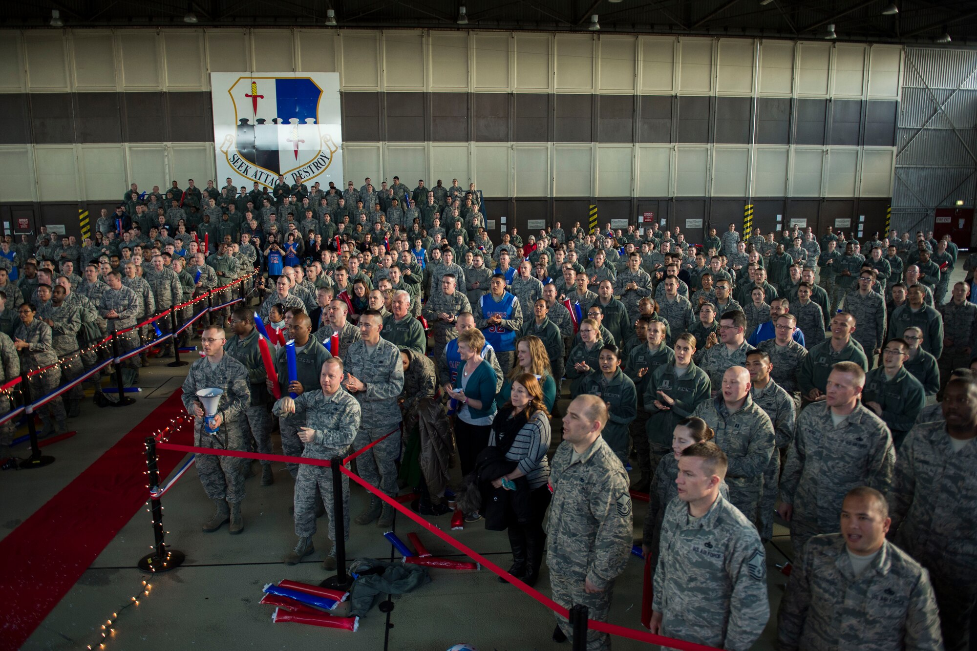 Spangdahlem community members sing the Air Force song at the conclusion of the Year in Review Pep Rally in Hangar 1 at Spangdahlem Air Base, Germany, Feb. 25, 2016. More than 500 people attended the event to support the 52nd Fighter Wing 2015 annual awards nominees. (U.S. Air Force photo by Airman 1st Class Luke Kitterman/Released)