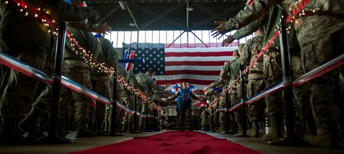 A 52nd Fighter Wing 2015 Annual Award nominee runs down the red carpet during the 2015 Year in Review Pep Rally in Hangar 1 at Spangdahlem Air Base, Germany, Feb. 25, 2016. Airmen congratulated the nominees on their accomplishments and cheered on their favorites to win the prestigious award during the event. (U.S. Air Force photo by Senior Airman Rusty Frank/Released)