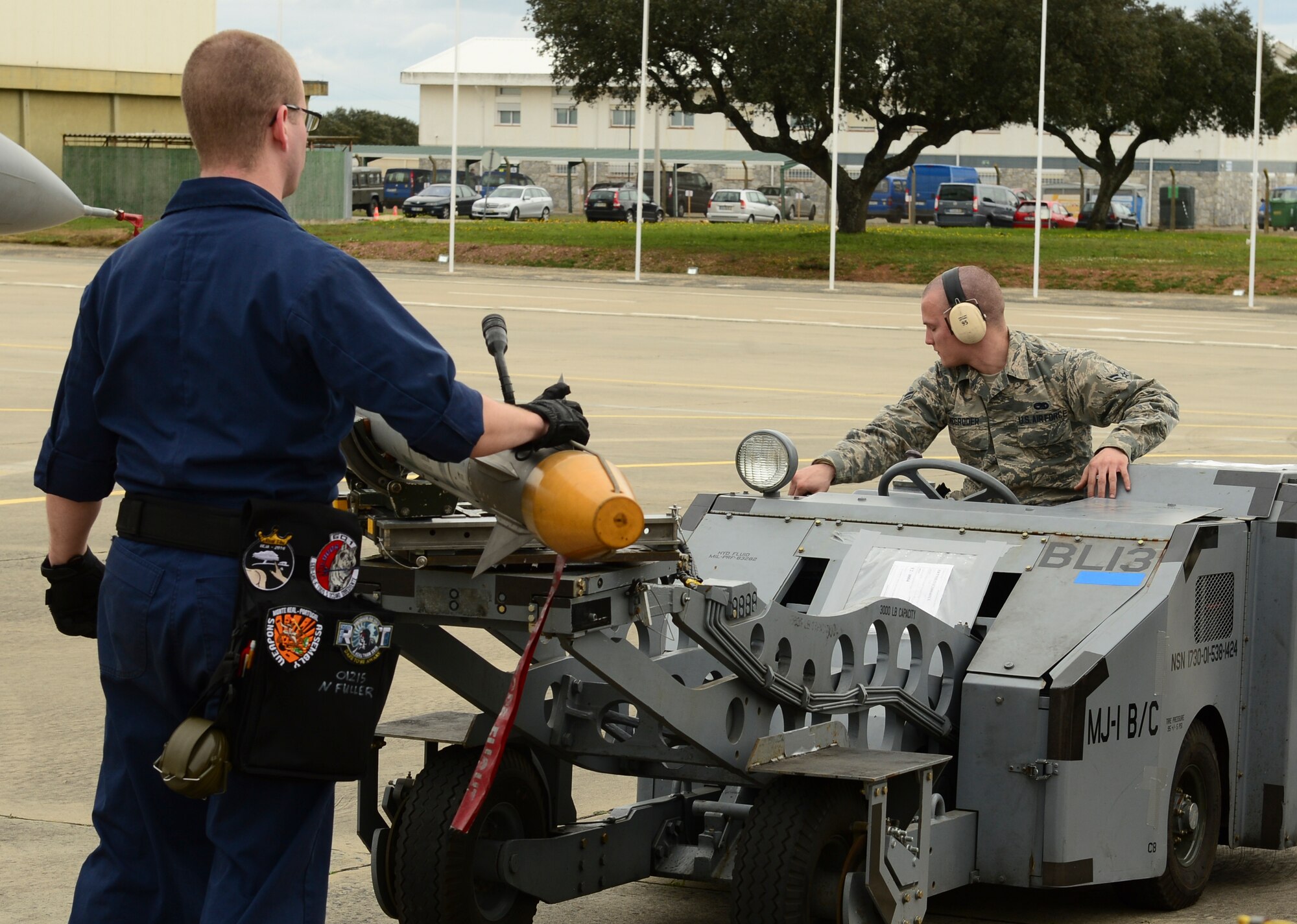 Senior Airman Noah Fuller and Airman 1st Class Edward McGroder, 493rd Aircraft Maintenance Unit weapons load crew members, transport simulated munitions on an MJ-1 Lift Truck during exercise Real Thaw at Beja Air Base, Portugal, Feb. 25, 2016. Real Thaw was designed to provide joint interoperability training throughout the execution of a vast range of battlefield missions, to include day and night operations in a high-intensity joint setting. (U.S. Air Force photo by Senior Airman Dawn M. Weber/Released)