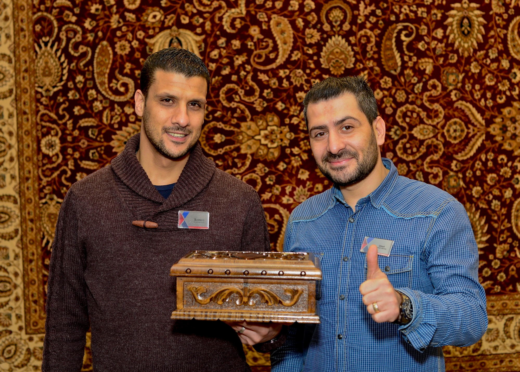 Romeo Ovelek, and Umut Nafile, shop owners in the Royal Air Forces Lakenheath and Mildenhall Base Exchanges, take a photo with a puzzle box similar to the one given to the daughter of fallen U.S. Marine Corps pilot Maj. Taj Sareen at Royal Air Force Mildenhall, England, Jan. 19, 2015. The box is similar to one ordered by Sareen as a gift for his daughter, before his tragic final flight Oct. 21, 2015. When notified of the untimely death of a recognized customer and member of the military family, the box was replaced by the shop owners, with the added engraving, “Daddy loves you always.” (U.S Air Force photo by Senior Airman Nigel Sandridge/Released)
