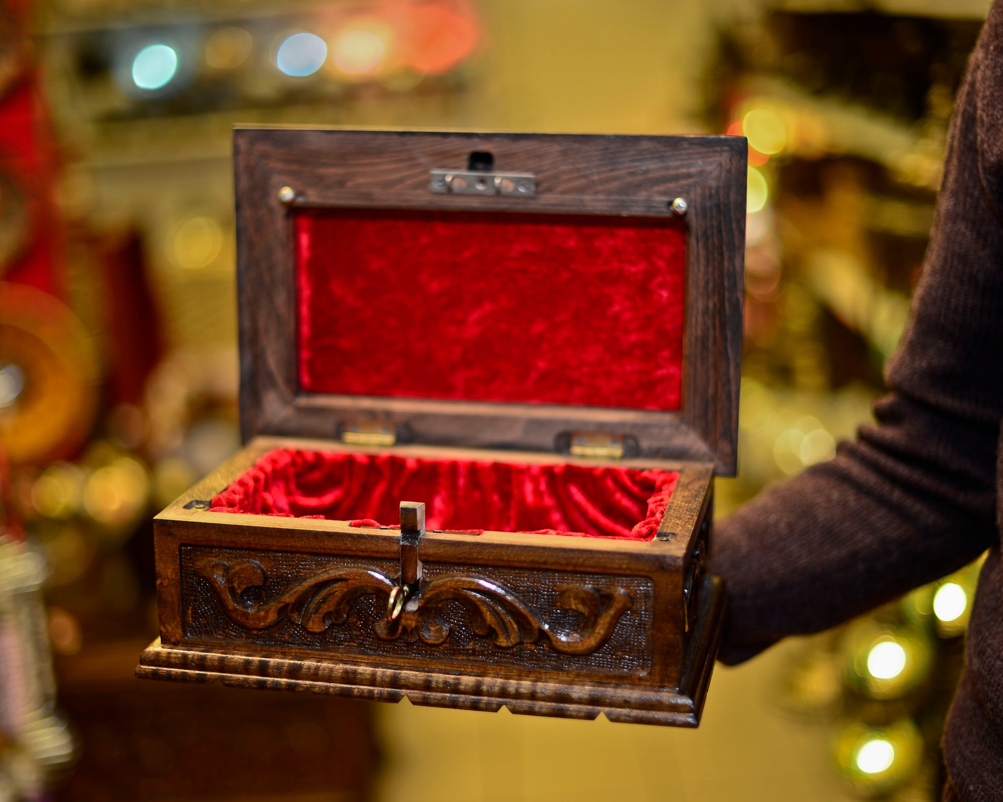 Romeo Ovelek, shop owner in the Base Exchange, displays a style of puzzle box similar to the one given to the daughter of fallen U.S. Marine Corps Maj. Taj Sareen, Jan. 19, 2015. Sareen originally ordered a puzzle box for his daughter, Jade, but the gift is thought to have been lost in his tragic, final flight Oct. 21, 2015. When notified of the untimely death of a recognized customer and member of the military family, the box was replaced by the shop owners, with the added engraving, “Daddy loves you always.” (U.S Air Force photo by Senior Airman Nigel Sandridge/Released)
