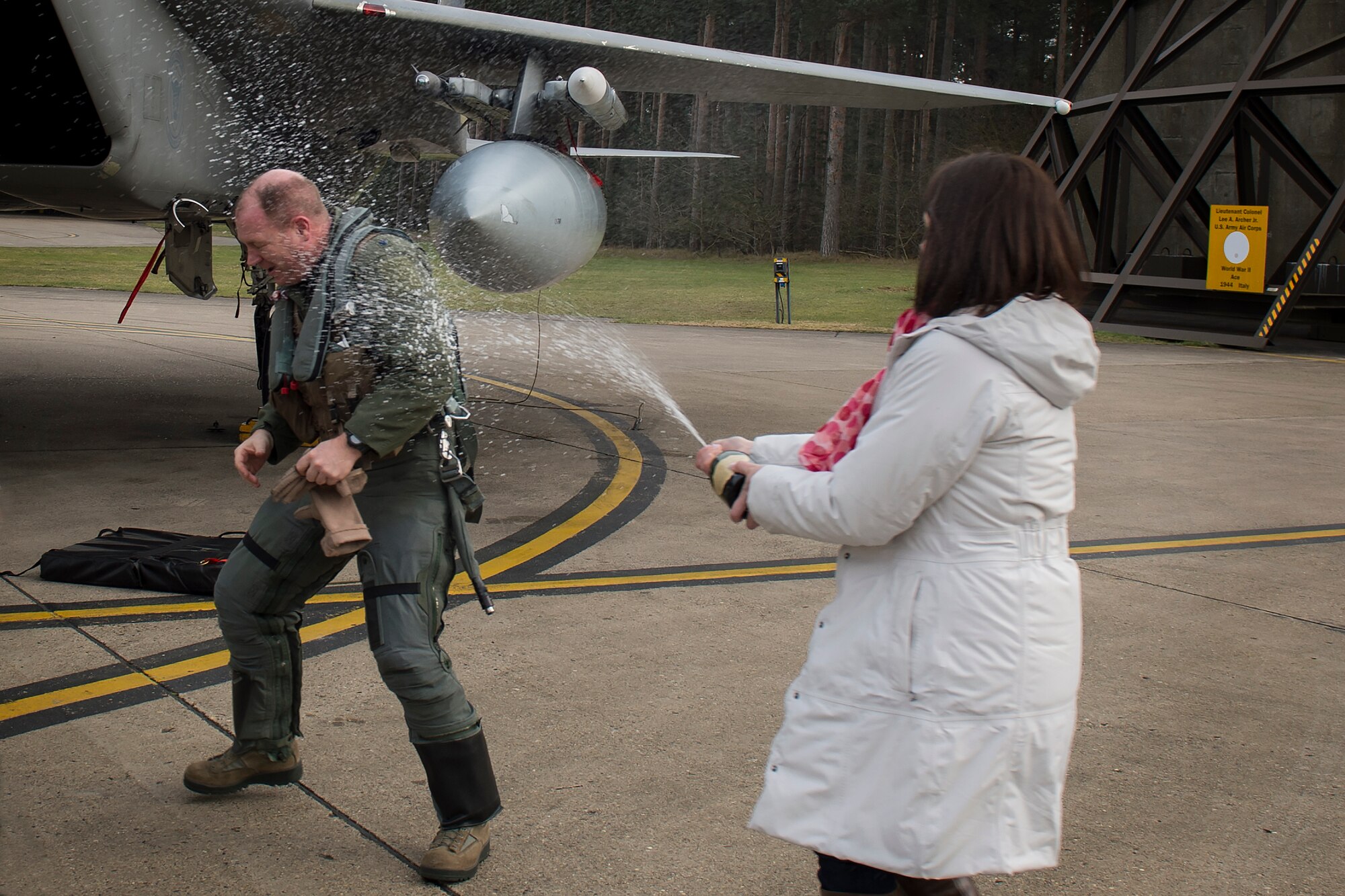 Tara Stratton, wife of Lt. Col. John Stratton, 493rd Fighter Squadron commander, sprays champagne in celebration of her husband earning his 2,000-hour flying milestone in the F-15C Eagle at Royal Air Force Lakenheath, England, Feb. 26, 2016. More than 30 friends, family members and fellow Airmen gathered to celebrate Stratton’s achievement.  (U.S. Air Force photo/Airman 1st Class Erin R. Babis)