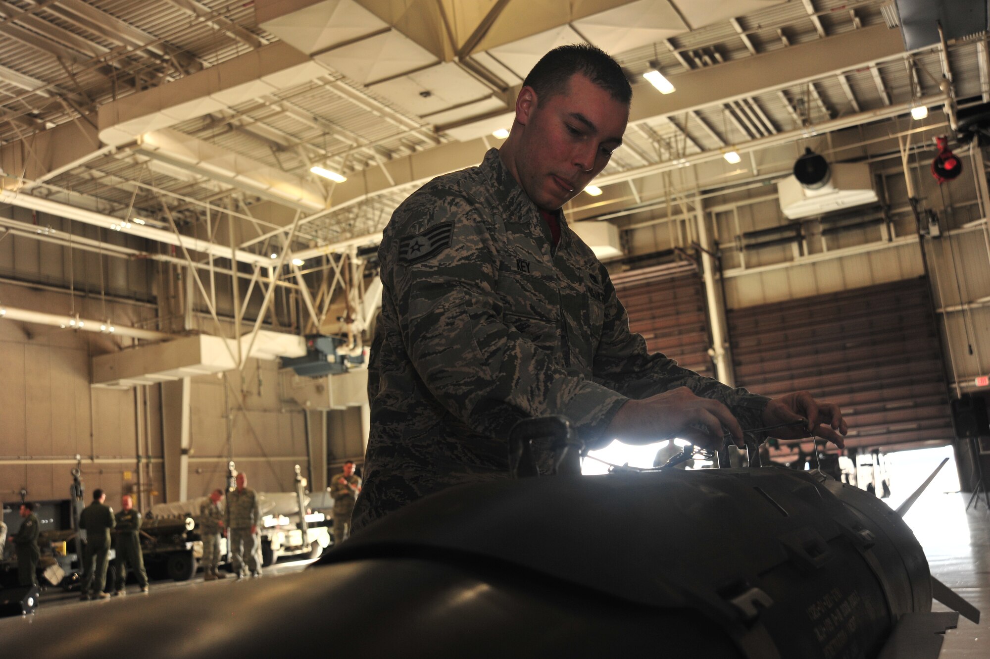 U.S. Air Force Staff Sgt. Jeremie Key, a load crew member assigned to the 131st Aircraft Maintenance Unit, surveys a trainer weapon during the annual Weapons Load Competition at Whiteman Air Force Base, Mo., Feb. 19, 2016. Load crew members must check for damages on all munitions before they are loaded. 