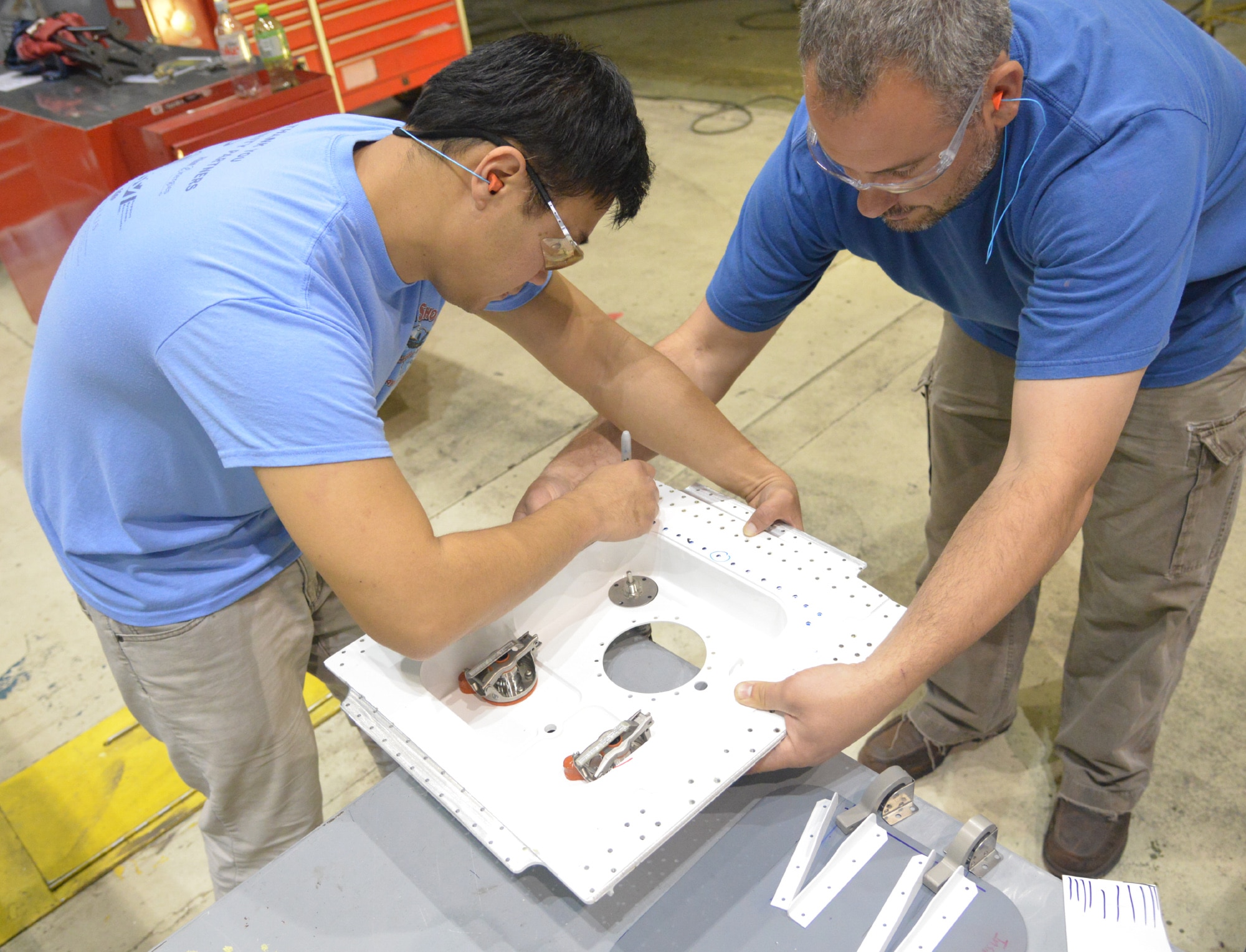 Terry Li, 402nd Aircraft Maintenance Support Squadron aircraft engineering supervisor, works on a waste service pan with Shawn Coffee, 562nd Aircraft Maintenance Squadron aircraft sheet metal worker. (U.S. Air Force photo by Ray Crayton)