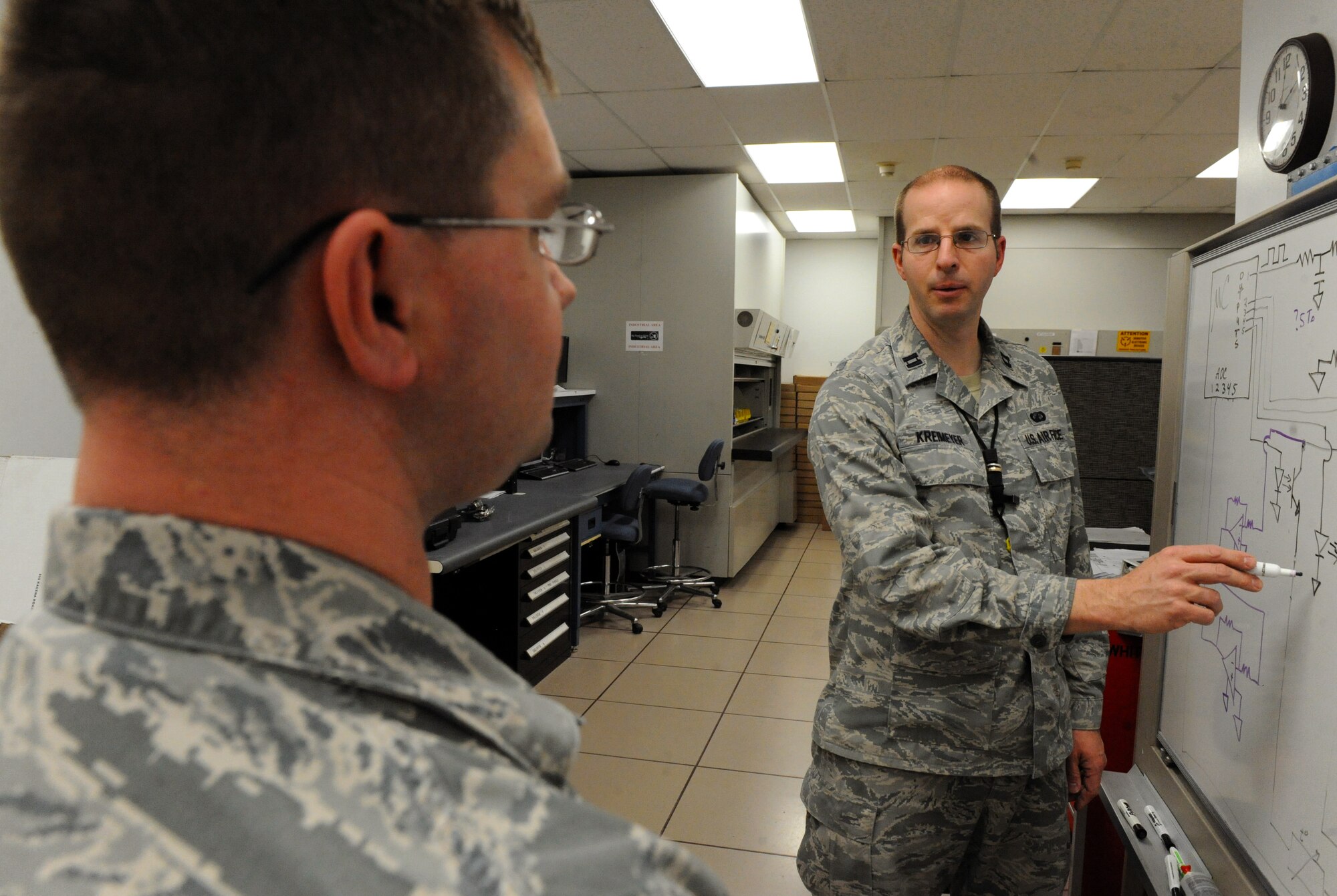 U.S. Air Force Capt. Wayne Kreimeyer, the 509th Maintenance Group (MXG) Research and Engineering (RE) flight commander, right, discusses circuit designs for a portable sensor tester with Tech. Sgt. Billy Doser, an RE technician with the 509th MXG, at Whiteman Air Force Base, Mo., Feb. 18, 2016. The tester, operated by micro-controllers, tests multiple sensors on hydraulic reservoirs from the B-2 aircraft by inputing a variety of voltages and displaying the results on an LCD. (U.S. Air Force photo by Tech. Sgt. Miguel Lara III)