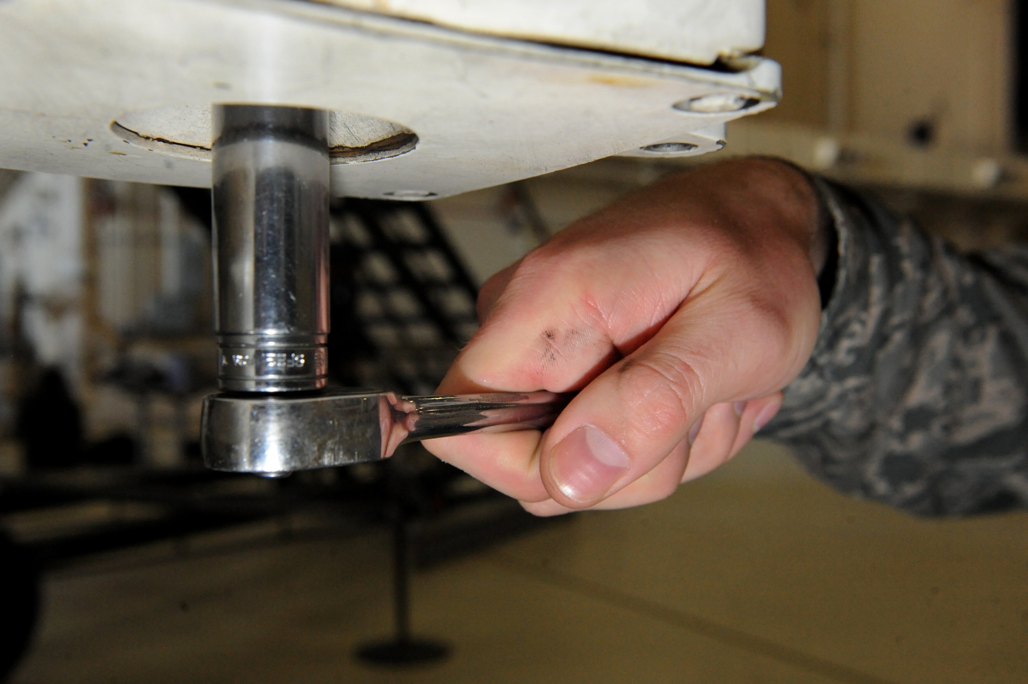 U.S. Air Force Tech Sgt. Aaron Bradley, a 393d Aircraft Maintenance Unit specialist section chief, adjusts the front landing gear of a B-2 Spirit with a socket wrench at Whiteman Air Force Base, Mo., Feb. 18, 2016. A second member, located in the cockpit, communicates with Bradley through headsets, allowing the specialists to adjust the steering of the front landing gear without turning the wheel. (U.S. Air Force photo by Tech. Sgt. Miguel Lara III)