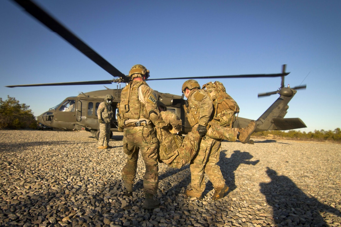 An airman and an Army Green Beret carry a simulated casualty to a UH-60 Black Hawk helicopter during Exercise Eagle Eye at Warren Grove Gunnery Range, N.J., Feb. 18, 2016. New Jersey National Guard photo by Air Force Tech. Sgt. Matt Hecht