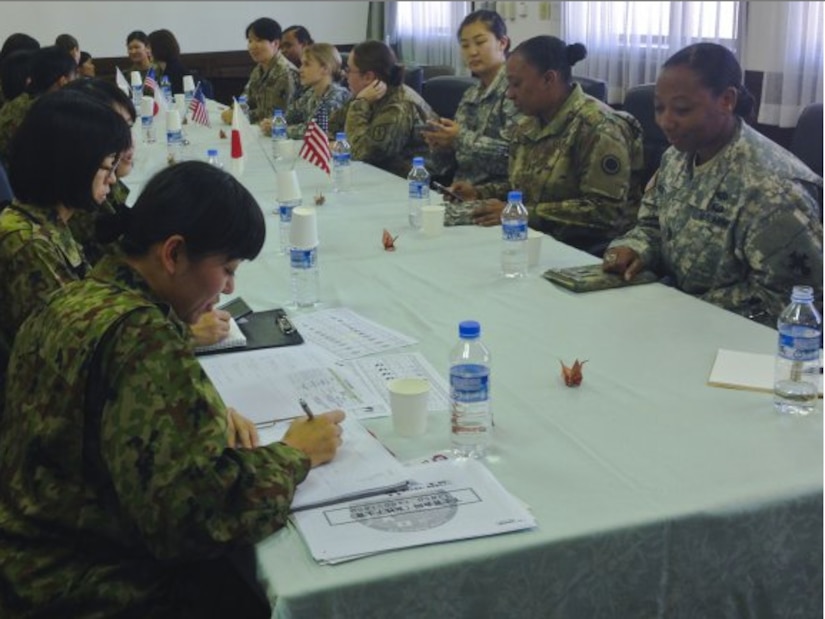 Japanese Service members take notes on some of the differences between the way their services approach women in uniform at Camp Itami, Japan, Dec. 5, 2015.