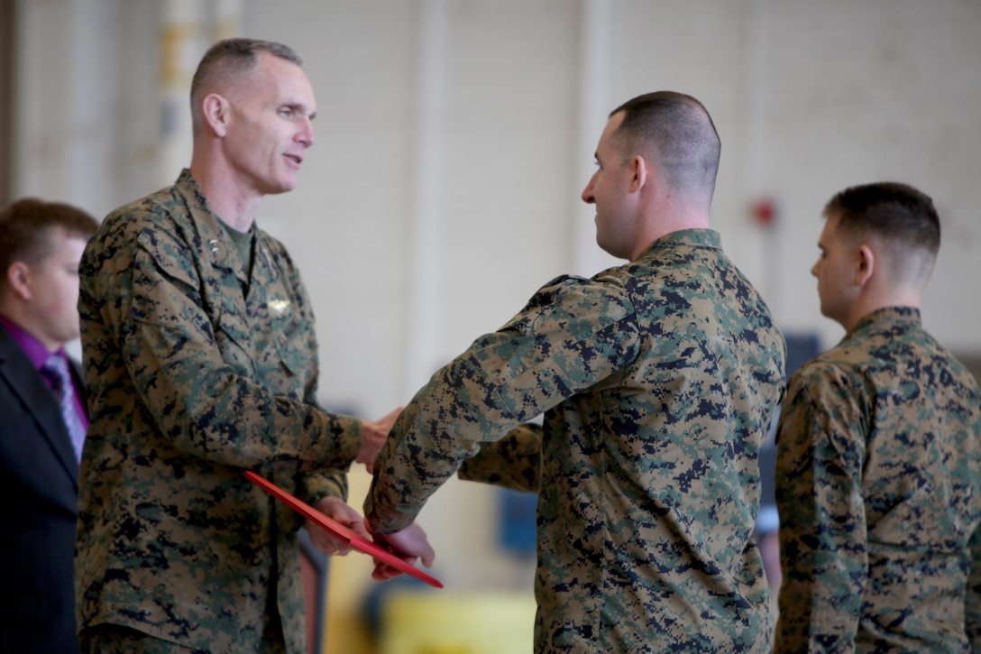 Maj. Gen. Gary L. Thomas congratulates and hands Sgt. Eric Foldvary a certificate of course completion at the conclusion of a Squadron Intelligence Training and Certification Course at Mid Atlantic Electronic Warfare Range, N.C., Feb. 12, 2016. To date, the course has certified more than 300 Marines enabling them to better integrate into the Marine Air-Ground Task Force. Thomas is the commanding general of 2nd MAW, Foldvary is an intelligence specialist with Marine Aircraft Group 14.  (U.S. Marine Corps photo by Cpl. Jason Jimenez/Released)