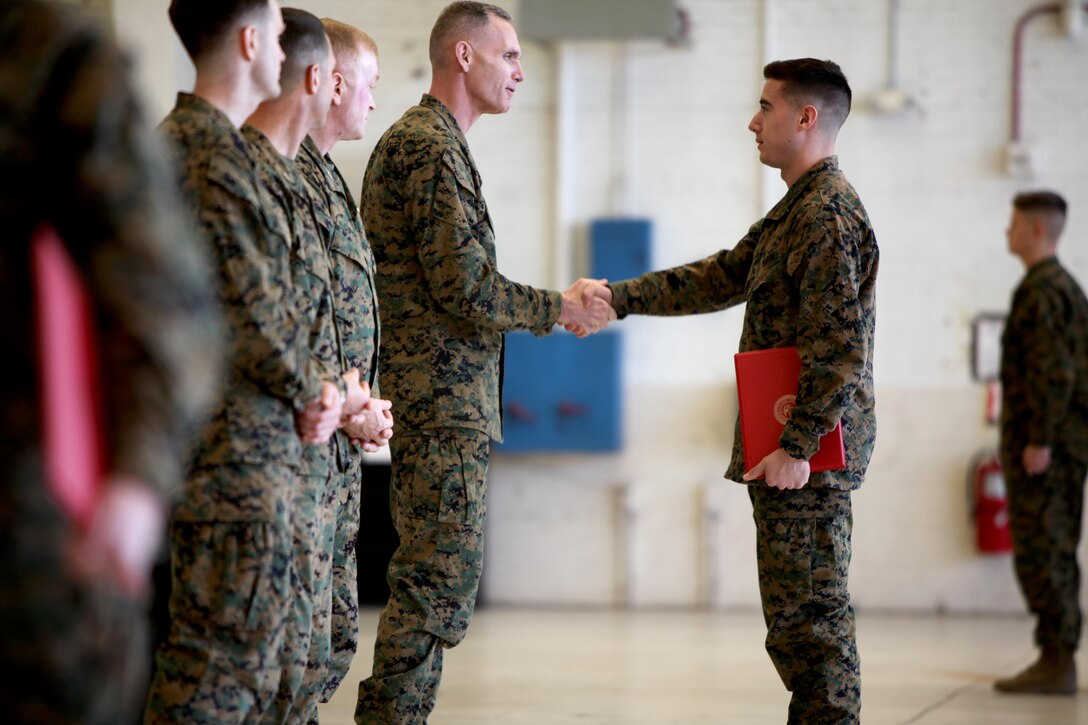 Maj. Gen. Gary L. Thomas congratulates Lance Cpl. Kurt Bright during a graduation ceremony at the conclusion of a Squadron Intelligence Training and Certification Course at Mid Atlantic Electronic Warfare Range, N.C., Feb. 12, 2016. To date, the course has certified more than 300 Marines enabling them to better integrate into the Marine Air-Ground Task Force. Thomas is the commanding general of 2nd MAW and Bright is an intelligence specialist with Marine Light Attack Helicopter Squadron 269. (U.S. Marine Corps photo by Cpl. Jason Jimenez/Released)