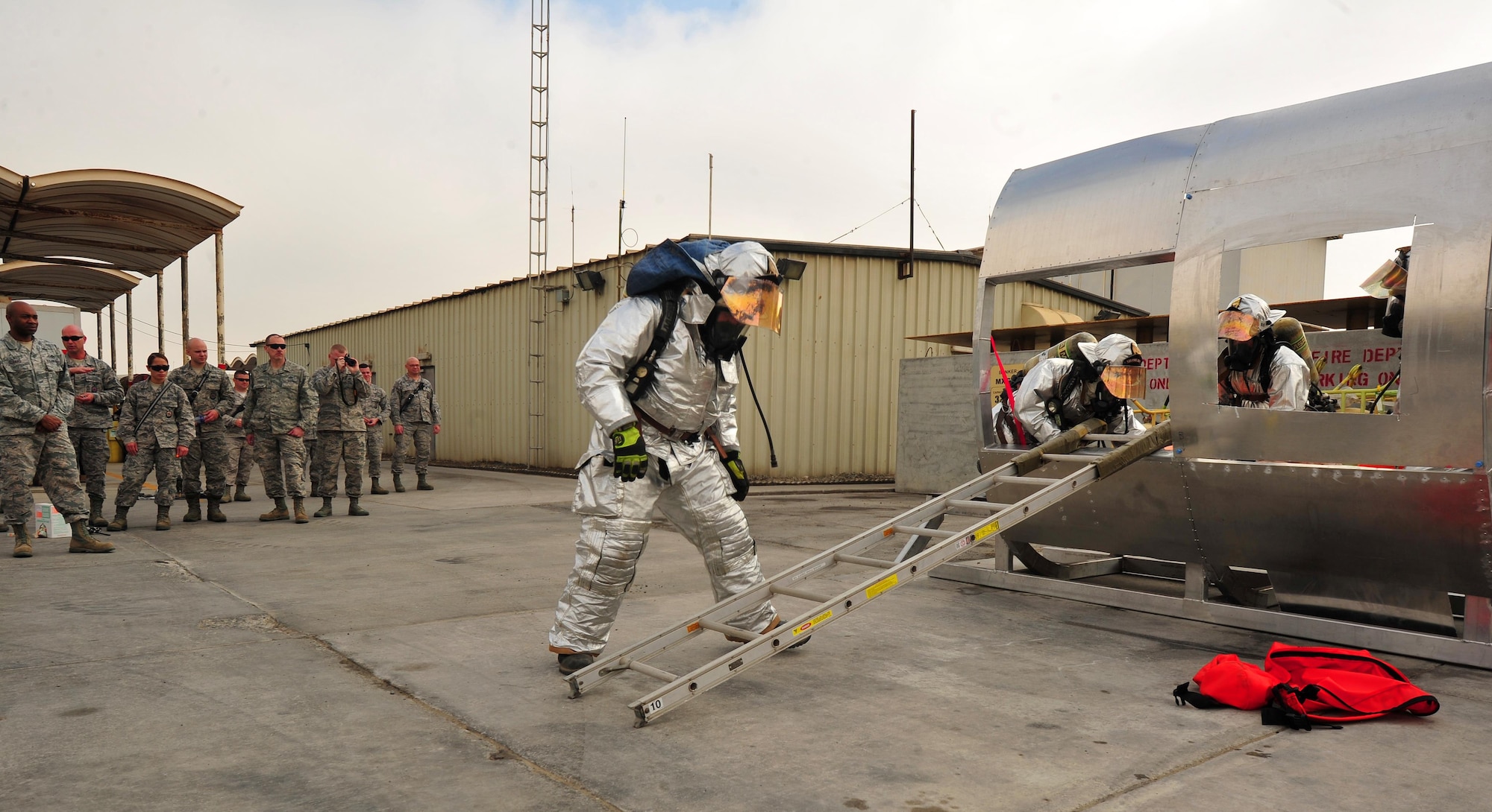 Firefighters from the 380th Expeditionary Civil Engineering Squadron enact a live demonstration of a fire department search and rescue aircraft trainer during a ribbon-cutting ceremony at an undisclosed location in Southwest Asia, Feb. 19. The initial idea for the project came about nearly two months prior when an “idea fairy” approached Tech. Sgt. Scott, 380 ECES Fire Department crash crew chief, with suggestions to developinng the trainer. (U.S. Air Force photo by Staff Sgt. Kentavist P. Brackin/released)
