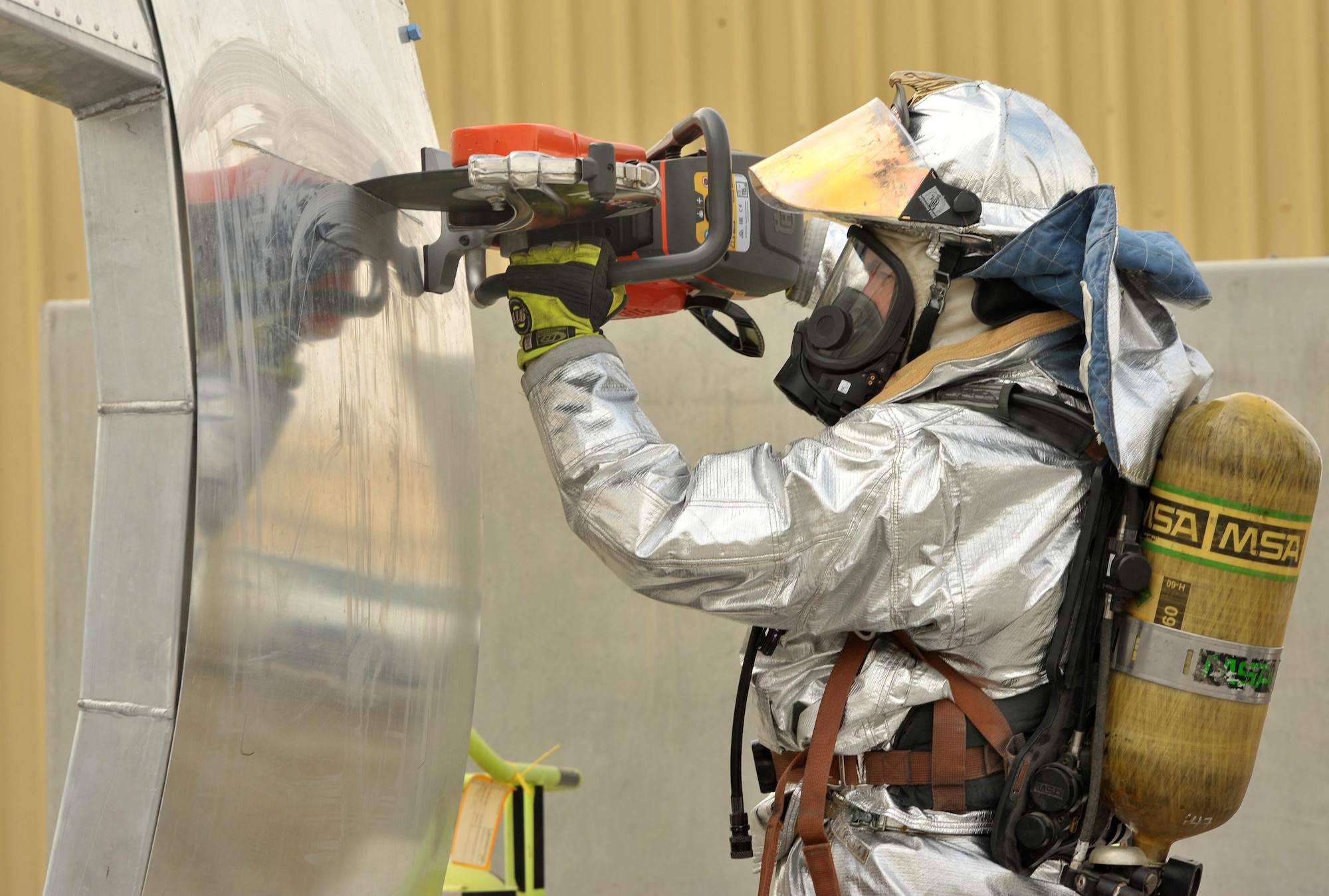 Tech. Sgt. Scott, 380th Expeditionary Civil Engineer Squadron Fire Department crash crew chief, cuts into a panel during a training demonstration of a search and rescue aircraft trainer at undisclosed location in Southwest Asia, Feb 19. The panels used on the trainer are replaceable, which means it can be repeatedly used by firefighters to keep their cutting skills sharp. (U.S. Air Force photo by Staff Sgt. Kentavist P. Brackin/released)