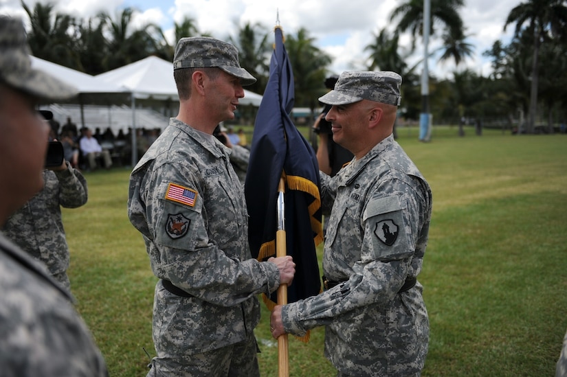 Maj. Gen. David Conboy transfers the colors to Brig. Gen. Rosende, entrusting him with the responsibility and care of the unit. Rosende accepted the flag from Conboy, as he assumed command as the 1st MSC’s fourth commander since it was officially activated in 2008, during a change of command ceremony at Maxie Williams Field, Fort Buchanan, Puerto Rico, Feb. 27. (U.S. Army photo by Spc. Anthony Martinez)