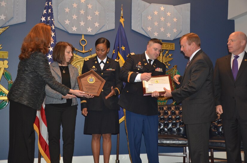 Capt. Michael Davis, commander, and 1st Lt. Amber Williams, both assigned to Forward Support Company, 980th Engineer Battalion, receive the 2015 Department of Defense Reserve Family Readiness Award during a ceremony at the Pentagon Hall of Heroes, Feb. 26, as the best FRG in the U.S. Army Reserve.