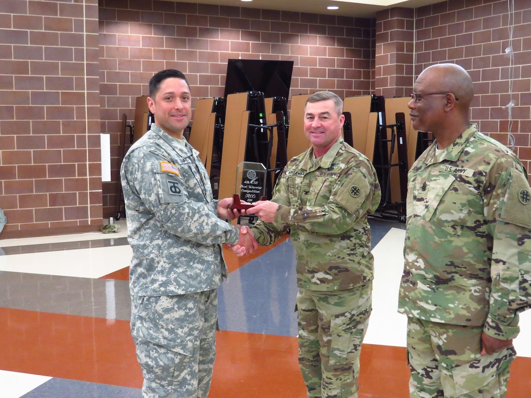 U.S. Army Staff Sgt. Hector Suarez, noncommissioned officer with the 851st Transportation Company, 319th Combat Sustainment Support Battalion, 211th Regional Support Group, 4th Sustainment Command (Expeditionary) (ESC) receives a plaque for winning the 2016 NCO Best Warrior Competition from Col. John A. Fontana the 4th ESC mission support element (MSE) Chief of Staff and Command Sgt. Maj. Larry D. Johnson, the 4th ESC MSE command sergeant major, at Joint Base San Antonio, Feb. 21, 2016. (U.S. Army Photo by Capt. Jose L. Caballero Jr./Released)