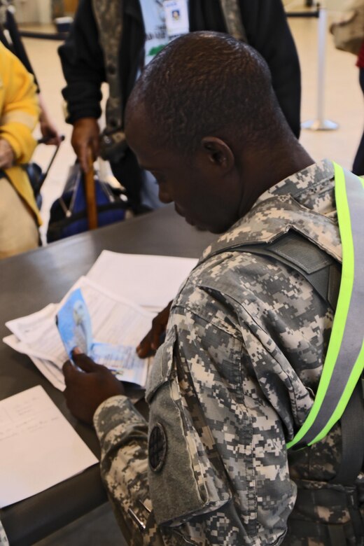 Spc. Kouadio Nguessan, an automated logistical specialist with the 103rd Quartermaster Company, verifies evacuee documents to ensure they have the necessary paperwork to reenter the country during a role play exercise, at the Intermediate Staging base on Feb. 18. This particular evacuee exercise is the first of its kind working directly with the Consulate out of Frankfurt Germany, while being the third iteration of similar training during the JRTC rotations. (U.S. Army Reserve Photo by Sgt. Bethany L. Huff)