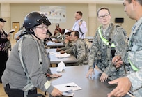 An evacuee needing medical attention is verified by Spc. Brandi Jayroe, a unit supply specialist with the 103rd Quartermaster Company, and Sgt. Gilbert Carda, a human resource specialist from 851st Transportation Company, during an evacuee operation exercise within the Joint Readiness Training Center rotation, at the Intermediate Staging base on Feb. 18. This highlights the essential assets and capabilities across the nation and globally to complement and enable the Total Army and the Joint Force in a realistic training scenario. (U.S. Army Reserve Photo by Sgt. Bethany L. Huff)