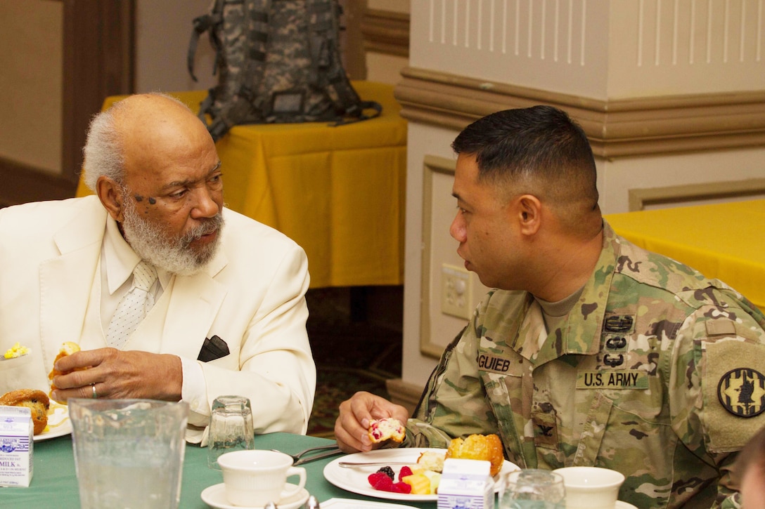 James H. Meredith (left), a prominent civil rights activist, talks with Col. Rosendo T. Guieb, commander of the 89th Military Police Brigade, Fort Hood, Texas, during a meal at an African-American/Black History Month Observance event Feb. 25, 2016, at Fort Hood. For Meredith, the 89th MP Brigade is special since it was the unit responsible for his safety during his historic attendance to the University of Mississippi in 1962. (U.S. Army photo by Sgt. Alexander Skripnichuk, 13th Public Affairs Detachment)