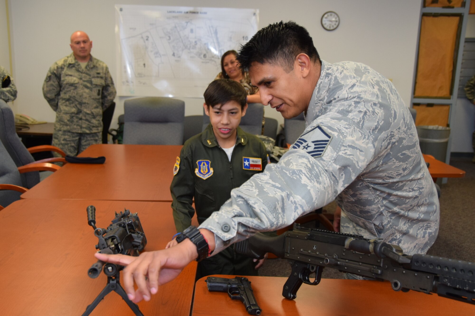Master Sgt. Manuel Camacho, a specialist with the 433rd Security Forces, talks about the weapons Air Force Security Forces members use while in combat to Zach Gutierrez, the 433rd Airlift Wing’s Pilot for a Day. Fifteen-year-old Zach was selected by the Children’s Hospital of San Antonio to participate in the inaugural program at the Alamo Wing. (U.S. Air Force photo by Tech. Sgt. Carlos J. Trevino)