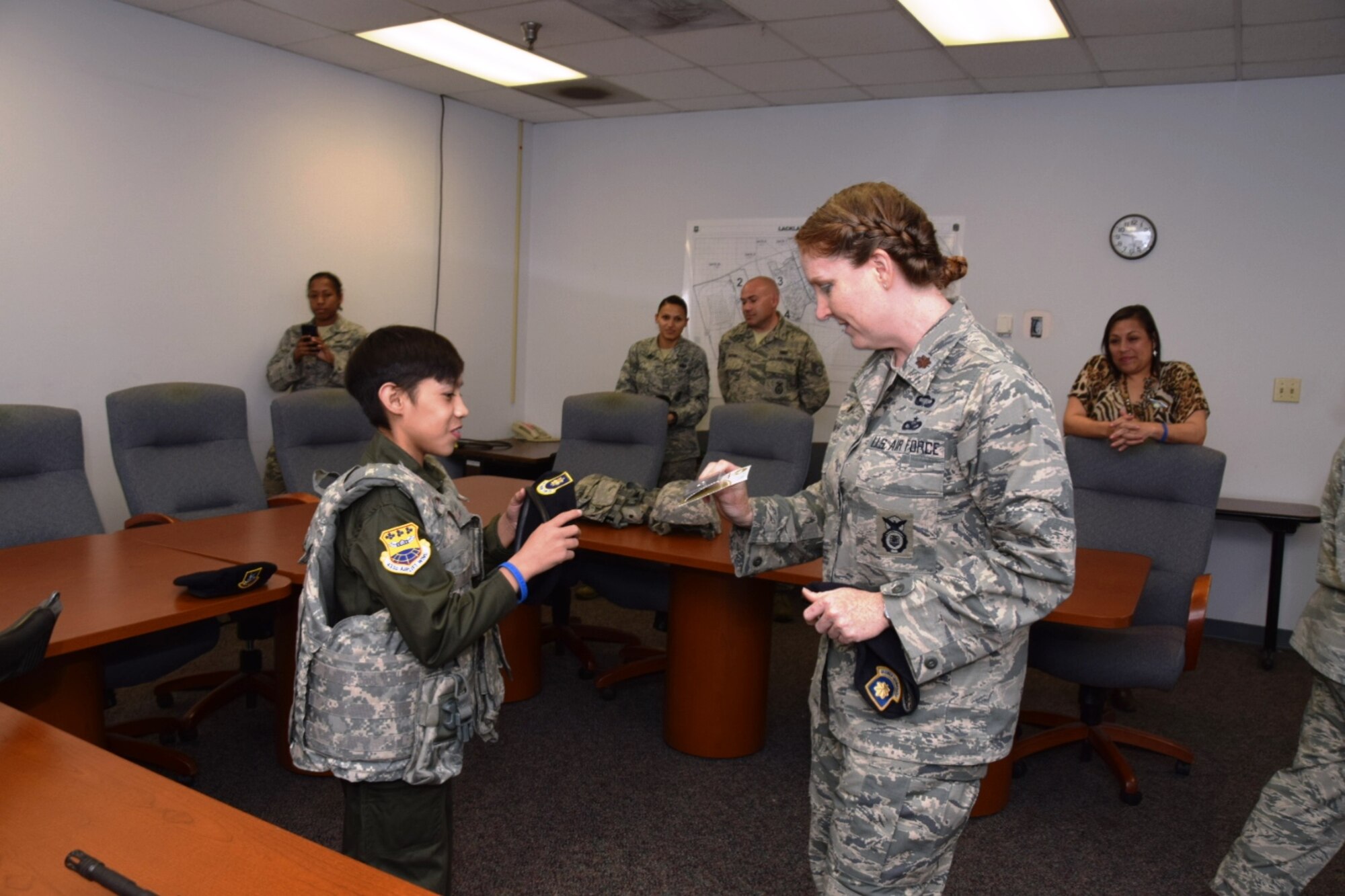 Maj. Korinne Sharp, commander of the 433rd Security Force Squadron, Joint Base San Antonio-Lackland, Texas coins Zach Gutierrez, the 433rd Airlift Wing’s Pilot for a Day, during his visit to her squadron, Feb. 28, 2016. Zach also was driven around the Wing in a patrol car belonging to the 433rd Security Forces Squadron.  (U.S. Air Force photo by Tech. Sgt. Carlos J. Trevino)