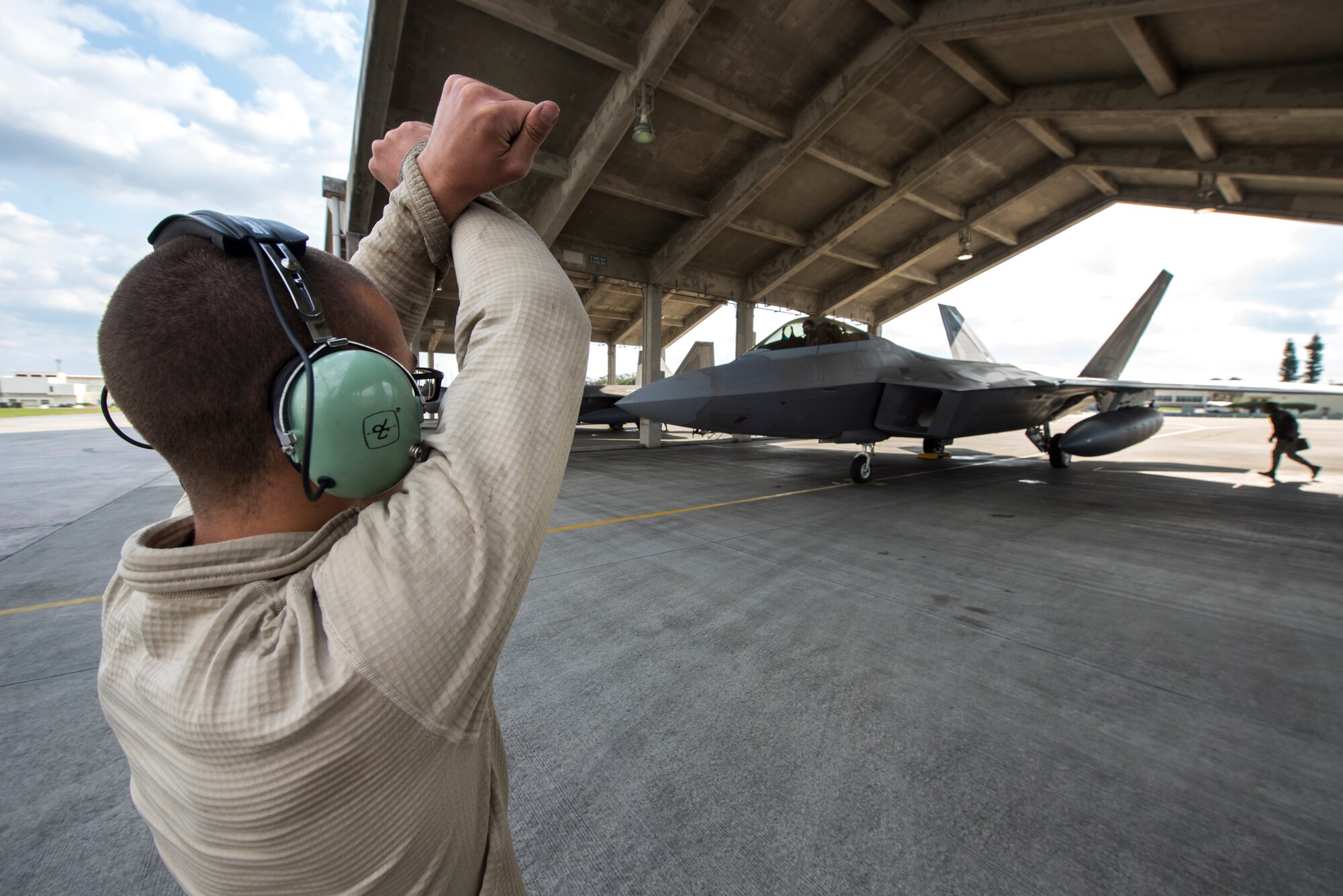 U.S. Air Force Senior Airman Liam Vining, 525th Aircraft Maintenance Unit crew chief, marshals an F-22 Raptor for takeoff Feb. 17, 2016, at Kadena Air Base, Japan. The Raptor took off alongside three others from the squadron before joining up with U.S. and Republic of Korea fighter aircraft over South Korea as a show of force in response to recent provocative action by North Korea. (U.S. Air Force photo by Staff Sgt. Maeson L. Elleman)