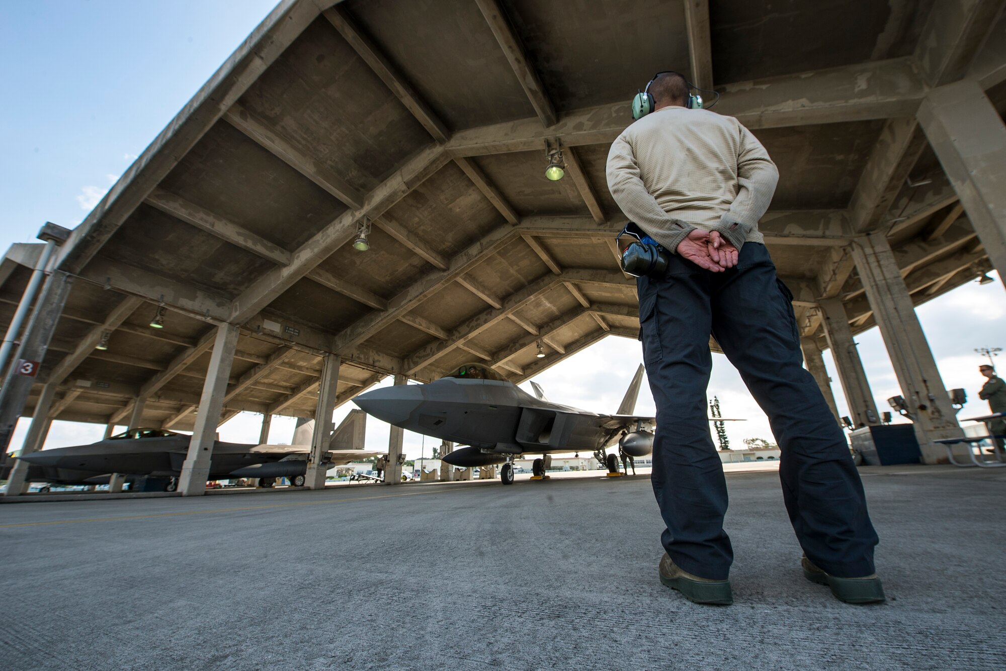 U.S. Air Force Senior Airman Liam Vining, 525th Aircraft Maintenance Unit crew chief, prepares to marshal an F-22 Raptor for takeoff Feb. 17, 2016, at Kadena Air Base, Japan. Four Raptors from the 525th FS conducted a combined formation flight alongside Republic of Korea F-15K Slam Eagles and U.S. Air Force F-16 Fighting Falcons in the vicinity of Osan Air Base, South Korea, to demonstrate the capabilities of the ROK-U.S. Alliance Feb. 17. (U.S. Air Force photo by Staff Sgt. Maeson L. Elleman)