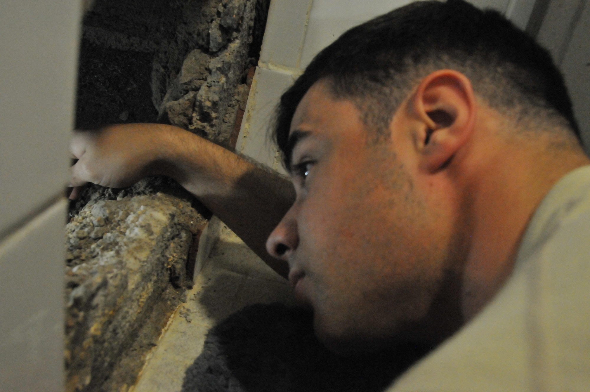Senior Airman Joshua Estrada, 379th Expeditionary Civil Engineer Squadron structural specialist, trouble shoots a bath tub leak Feb. 23 at Al Udeid Air Base, Qatar.  Estrada investigates the leak to see if it is a structural issue or if plumbers need to be notified of the situation. (U.S. Air Force Photo by Tech. Sgt. Terrica Y. Jones)