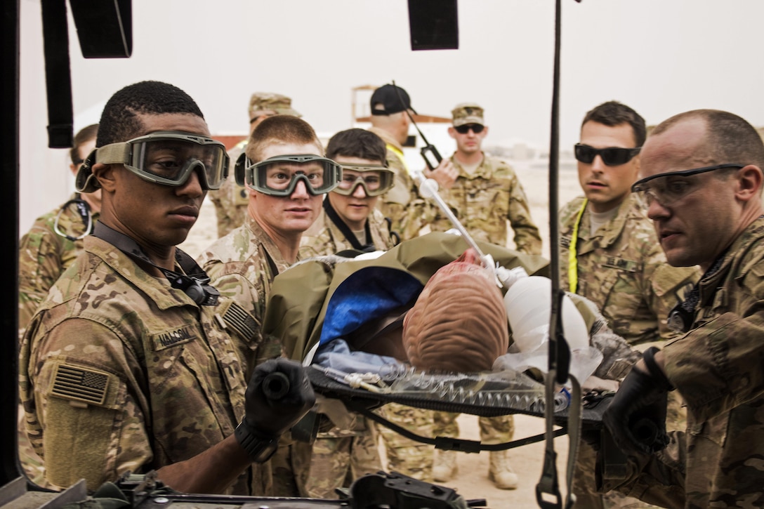 Soldiers load a simulated patient onto an ambulance at a tactical combat casualty care lane at Camp Buehring, Kuwait, Feb. 23, 2016. The soldiers are assigned to the 1st Battalion, 63rd Armor Regiment. U.S. Army photo by Staff Sgt. Ian M. Kummer