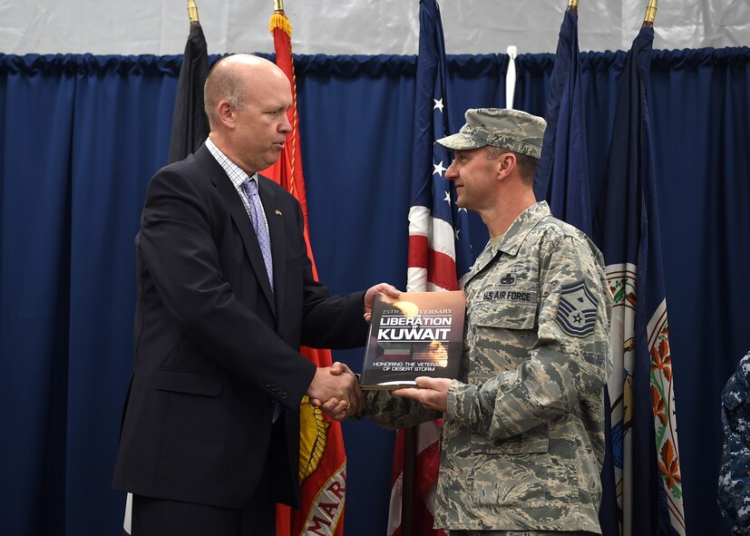 Gulf War veteran Senior Master Sgt. Charles Witt receives a book commemorating the 25th Anniversary of the Liberation of Kuwait during a ceremony aboard the USS Arlington (LPD 24) in Kuwait, Feb. 23, 2016. Witt was among six American and four Kuwaiti Gulf War veterans who attended the ceremony. (U.S. Air Force photo by Staff Sgt. Jerilyn Quintanilla)