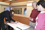 From left, Clothing and Textiles supply planner Aileen Dungee discusses a user-friendly job aids database she created with the help of Continuous Process Improvement supervisory program analyst Henry Jansen and team members David Cortes and Karla Van Horn for DLA Troop Support Philadelphia. 