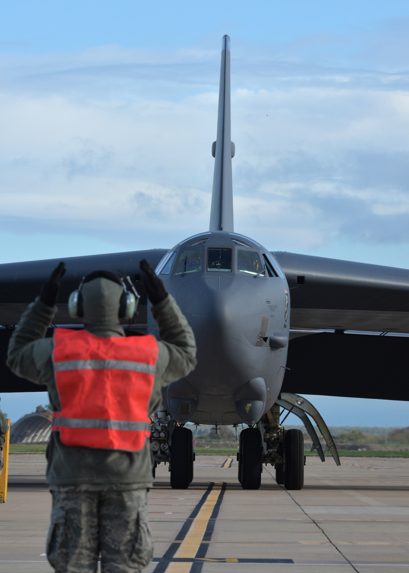A crew chief from the 2nd Expeditionary Bomb Group guides a B-52 Stratofortress into its parking spot at Morón Air Base, Spain, Feb. 27, 2016. This B-52 and two others will join KC-135 Stratotankers and F-16 Fighting Falcons as the U.S. air component during Cold Response 16, a biennial NATO military exercise. Participants will experience sub-freezing temperatures in the Trøndelag region of Norway over the course of the nearly two-week exercise. (U.S. Air Force photo/Senior Airman Joseph Raatz)
