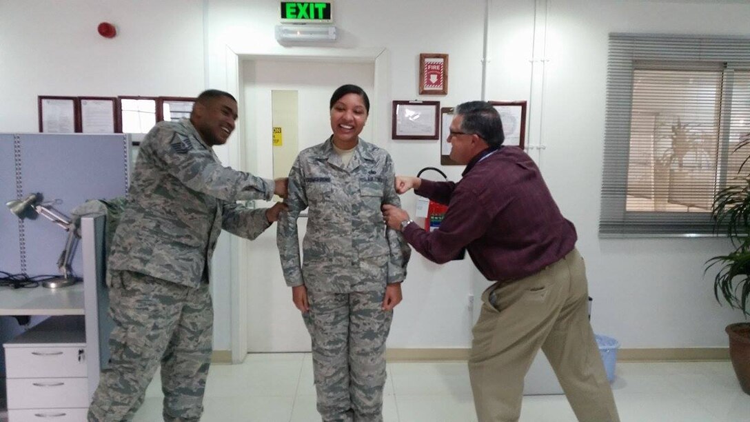 Air Force Master Sgt. Tiant Young and DLA Distribution Bahrain deputy commander Paul McMillan join Air Force Tech. Sgt. Adreana Freeman-Irons during her promotion ceremony on Feb. 7.