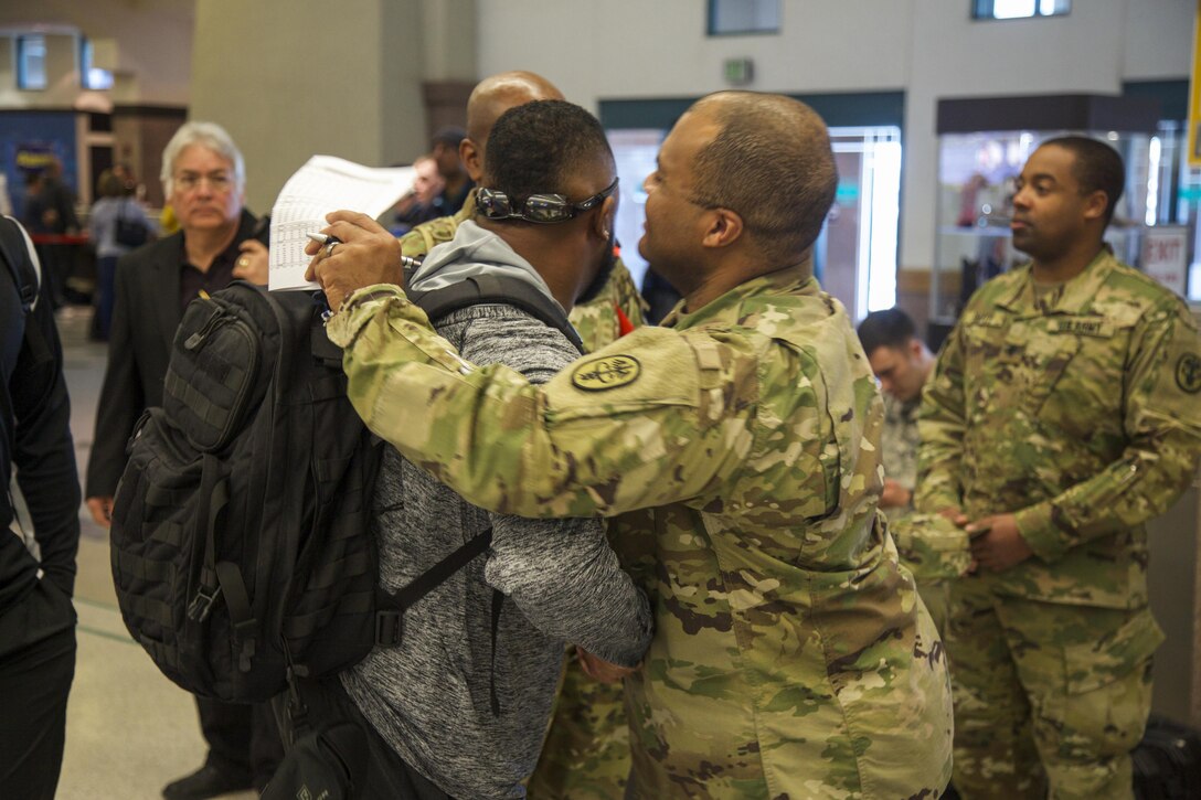 Army Maj. Rodney Lamberson, an Army Trials action officer, greets active duty soldiers and veterans who will be participating in the 2016 Warrior Trials at Fort Bliss, Texas, at El Paso International Airport, El Paso, Texas, Feb. 26, 2016. More than 100 wounded, ill and injured Soldiers and veterans are on Fort Bliss to train and compete in a series of athletic events including archery, cycling, shooting, sitting volleyball, swimming, track, and field, and wheelchair basketball. Army Trails, March 6-10, are conducted by the Department of Defense Warrior Games 2016 Army Team, Approximately 250 athletes, representing teams from the Army, Marine Corps, Navy, Air Force, Special Operations Command and the British Armed Forces will compete in the DoD Warrior Games June 14-22 at the U.S. Military Academy, West Point, N.Y. U.S. Army photo by Spc. Jensen Craig