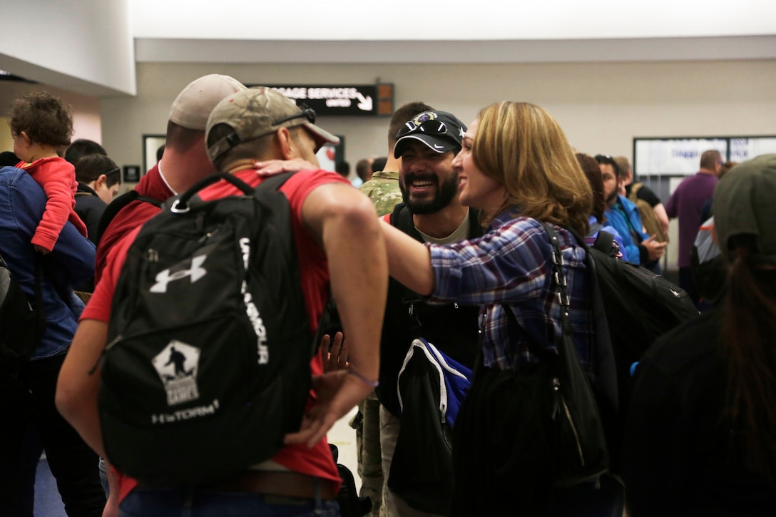 Army active duty and veterans greet each other while they wait to gather their luggage at the El Paso International Airport, El Paso, Texas, Feb. 26, 2016. More than 100 wounded, ill and injured Soldiers and Veterans are at Fort Bliss to train and compete in a series of athletic events including archery, cycling, shooting, sitting volleyball, swimming, track, and field, and wheelchair basketball. Army Trails, March 6-10, are conducted by the Department of Defense Warrior Games 2016 Army Team, Approximately 250 athletes, representing teams from the Army, Marine Corps, Navy, Air Force, Special Operations Command and the British Armed Forces will compete in the DoD Warrior Games June 14-22 at the U.S. Military Academy, West Point, N.Y. U.S. Army photo by Spc. Adasia Ortiz