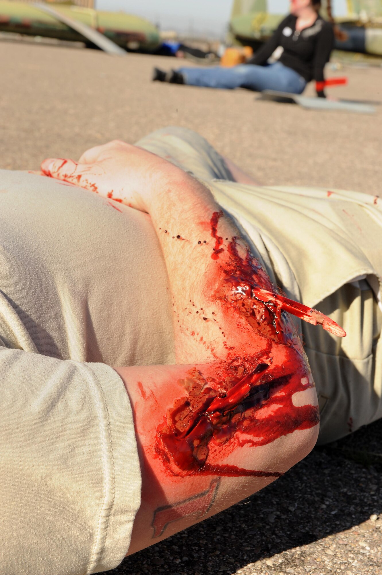 U.S. Air Force Staff Sgt. Ethan Owen, 355th Force Support Squadron moral, welfare and recreation liaison, lays on the ground with simulated wounds during the BUSHWHACKER 16-02 Aircraft Crash emergency management exercise at Davis-Monthan Air Force Base, Ariz., Feb. 24, 2016. Forty-five Airmen volunteered to simulate crash victims to make the exercise more realistic. (U.S. Air Force photo by Senior Airman Cheyenne A. Powers/ Released) 