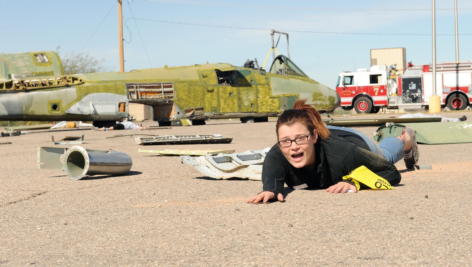 U.S. Air Force Senior Airman Kaylah Cook, 12th Air Force knowledge manager, crawls on the ground for help while simulating an aircraft crash victim with a broken leg during the BUSHWHACKER 16-02 Aircraft Crash emergency management exercise at Davis-Monthan Air Force Base, Ariz., Feb. 24, 2016. Forty-five Airmen volunteered to simulate crash victims to make the exercise more realistic. (U.S. Air Force photo by Senior Airman Cheyenne A. Powers/ Released)